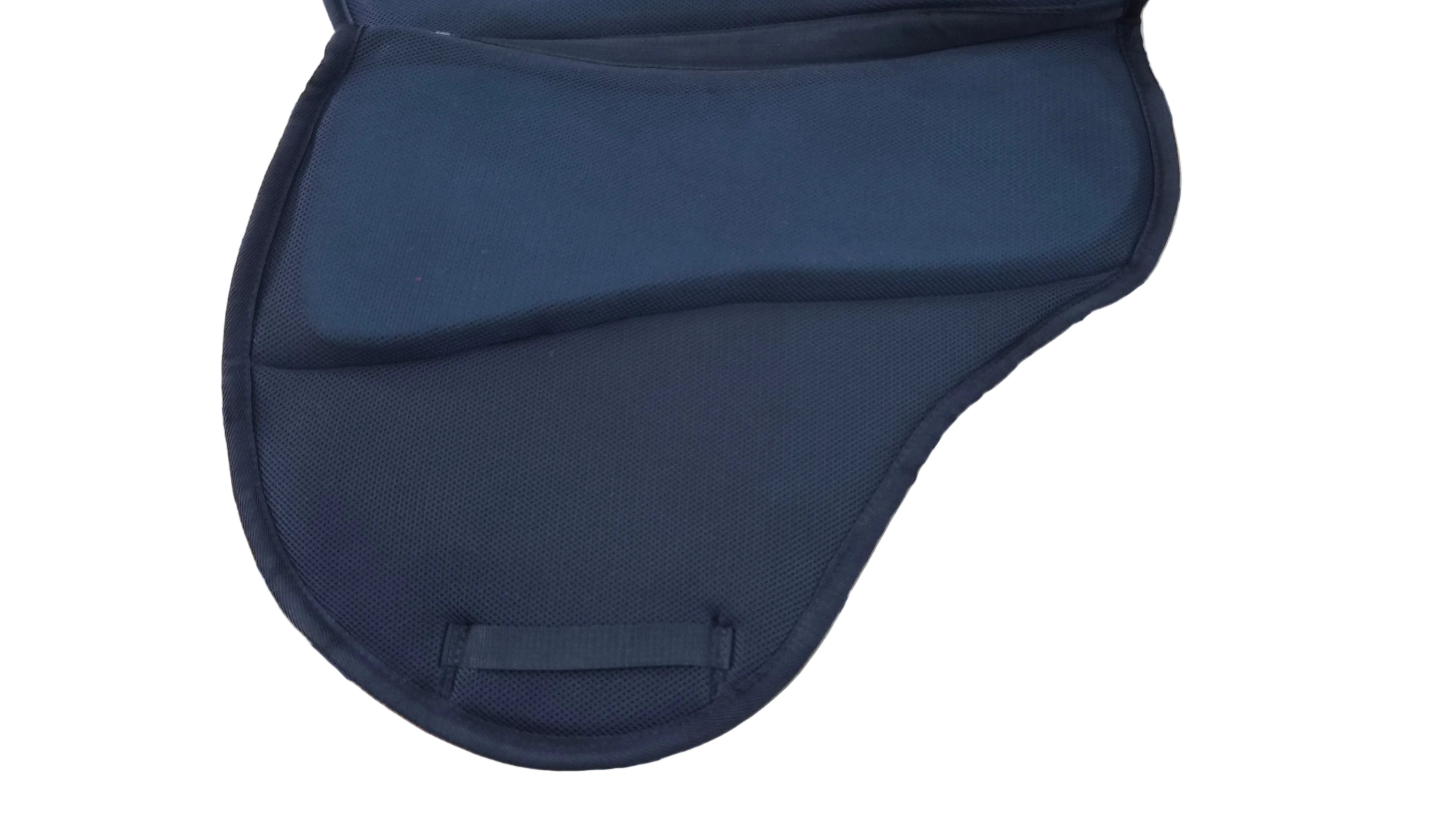 A black padded saddle pad or horse blanket laid flat on a beige tiled floor.